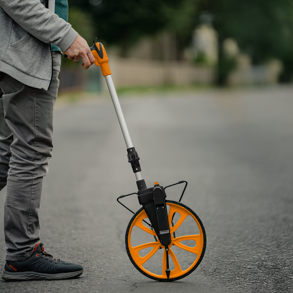 Surveyor's measuring wheel with mechanical counter and folding handle for site investigation